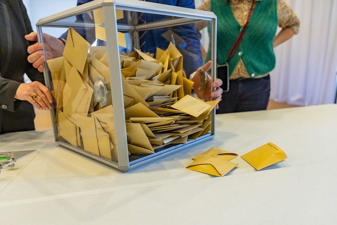 Le Président du bureau de vote a ouvert l'urne et verse les bulletins sur la table pour procéder au dépouillement. 